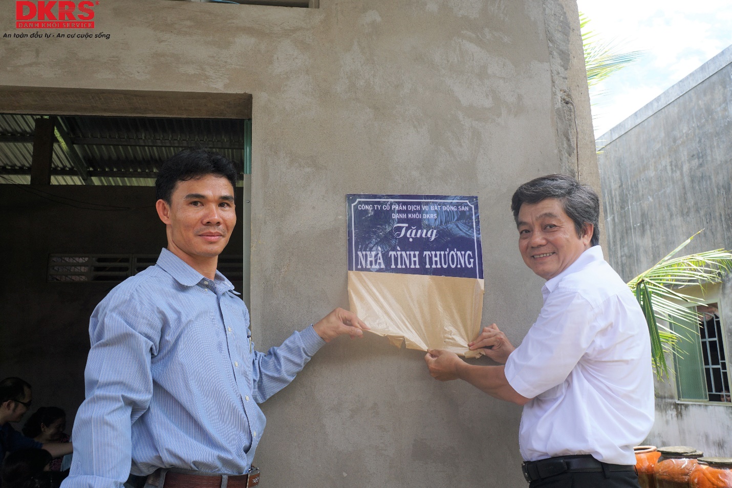 Ông Nguyễn Văn Nhựt (áo trắng) đại diện Công ty Danh Khôi DKRS và ông Trần Thanh Hải – Phó chủ tịch UBND xã Thới Lai cùng thực hiện nghi thức trao nhà